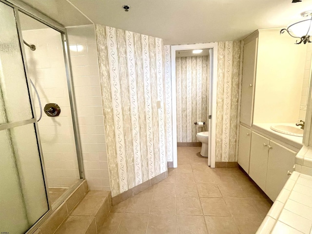 full bathroom with tile patterned flooring, a shower stall, and wallpapered walls