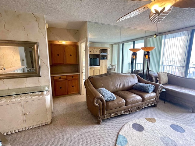 living area with light carpet, ceiling fan, and a textured ceiling