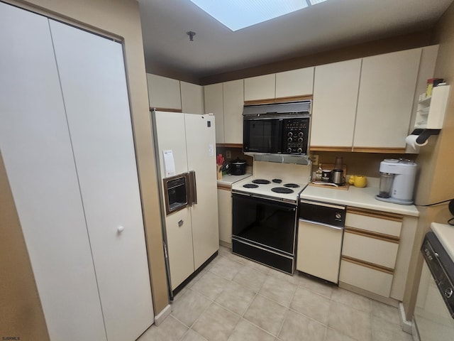 kitchen featuring light tile patterned floors, light countertops, white appliances, and white cabinetry