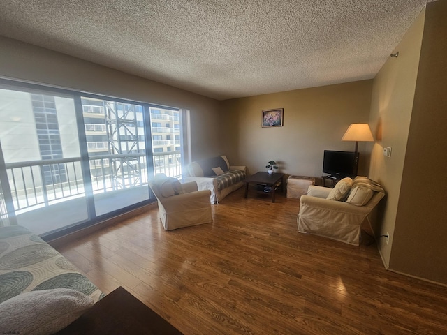 living room with a textured ceiling and wood finished floors