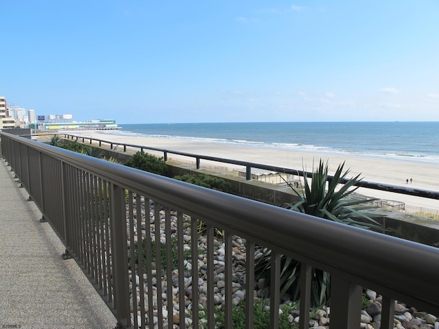 balcony featuring a water view and a beach view