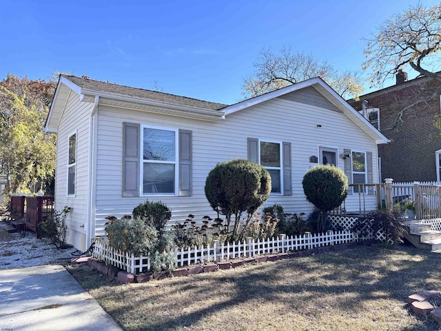 bungalow with a deck, roof with shingles, and fence