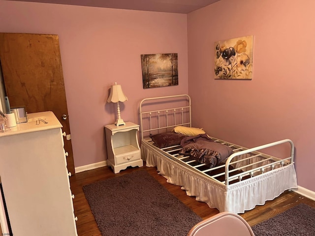 bedroom featuring dark wood-type flooring and baseboards