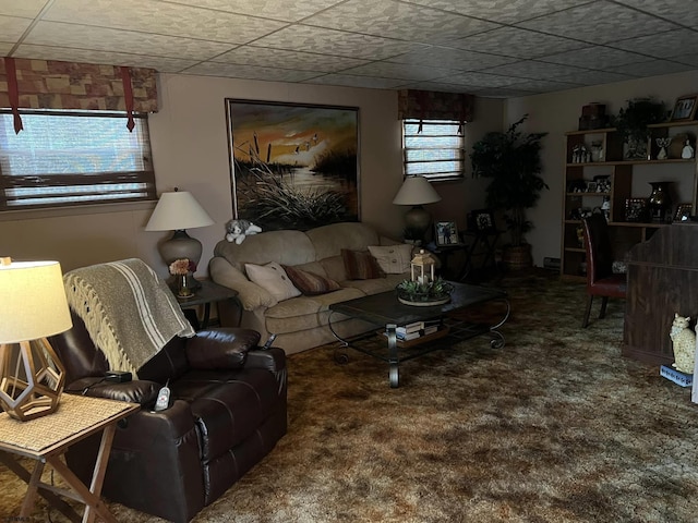 carpeted living area with a healthy amount of sunlight and a drop ceiling