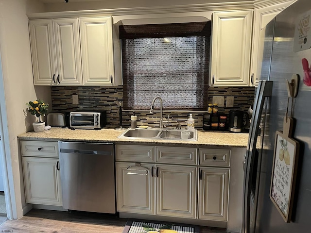 kitchen with a toaster, appliances with stainless steel finishes, tasteful backsplash, and a sink