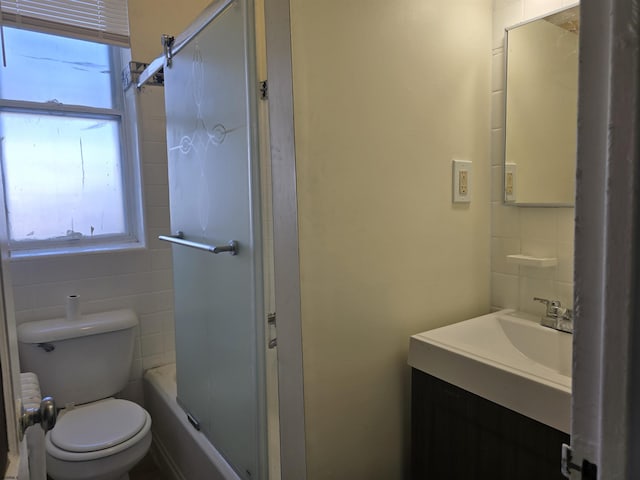 full bath with toilet, tile walls, and vanity