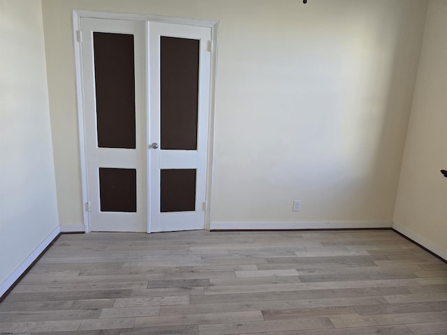 empty room featuring light wood-type flooring and baseboards