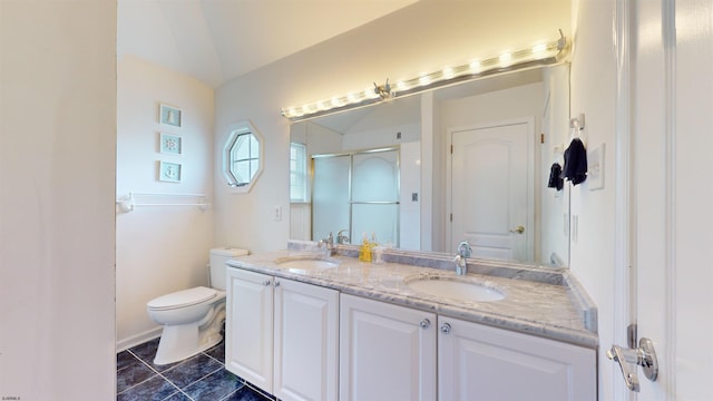 bathroom with double vanity, a stall shower, a sink, and toilet