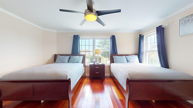 bedroom featuring ceiling fan, crown molding, and wood finished floors