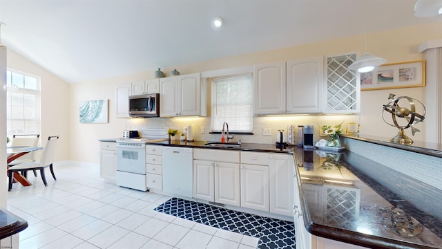 kitchen with white appliances, a sink, white cabinets, dark countertops, and decorative light fixtures