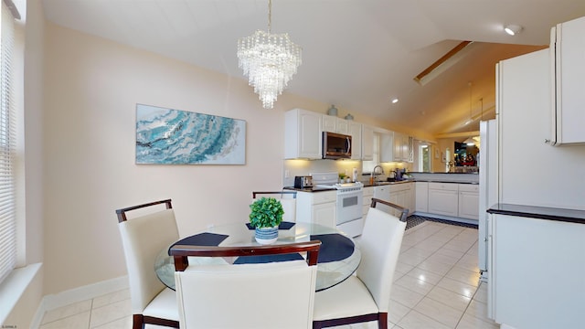 dining room with a notable chandelier, vaulted ceiling, baseboards, and light tile patterned floors