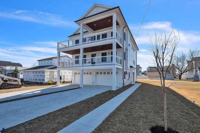 view of front facade with board and batten siding, driveway, a balcony, and a garage