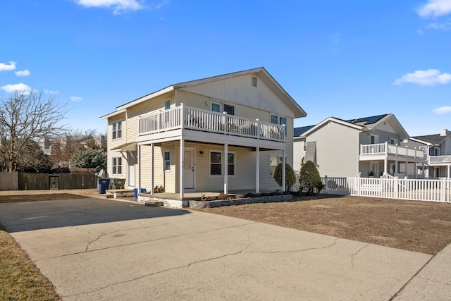 view of front of home with a balcony, a residential view, and fence