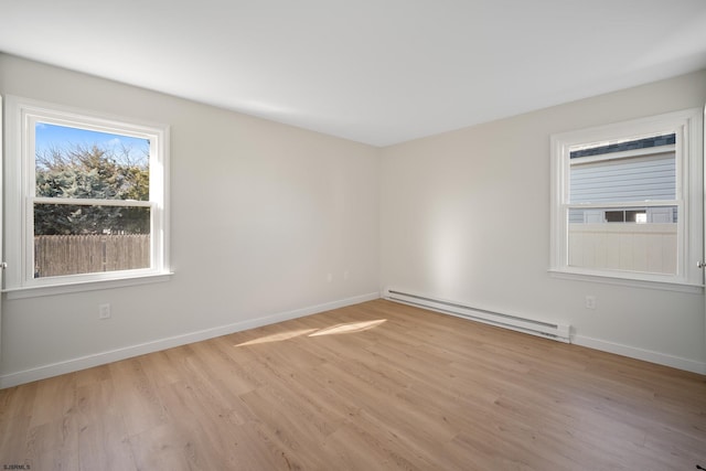 spare room featuring light wood-style floors, baseboards, and baseboard heating