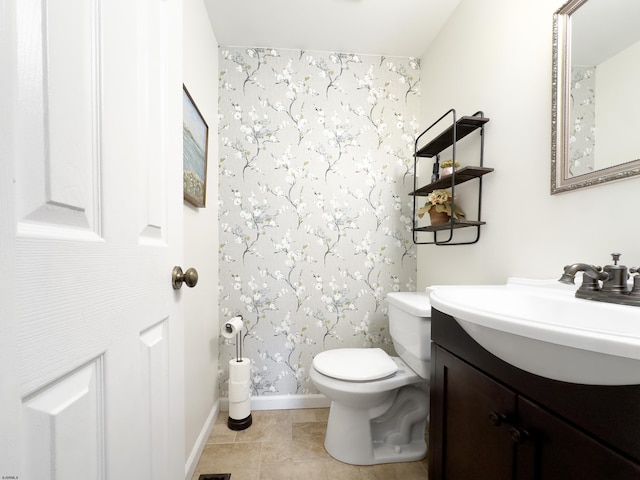 bathroom with vanity, toilet, and baseboards