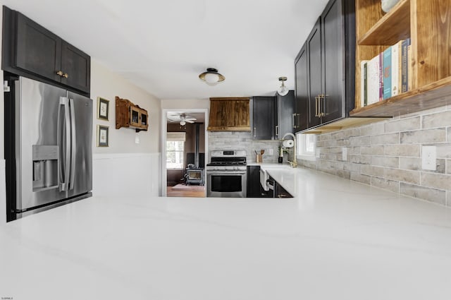 kitchen featuring open shelves, a peninsula, stainless steel appliances, and light countertops