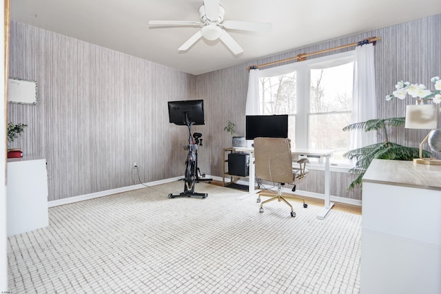 home office featuring wallpapered walls, a ceiling fan, and baseboards