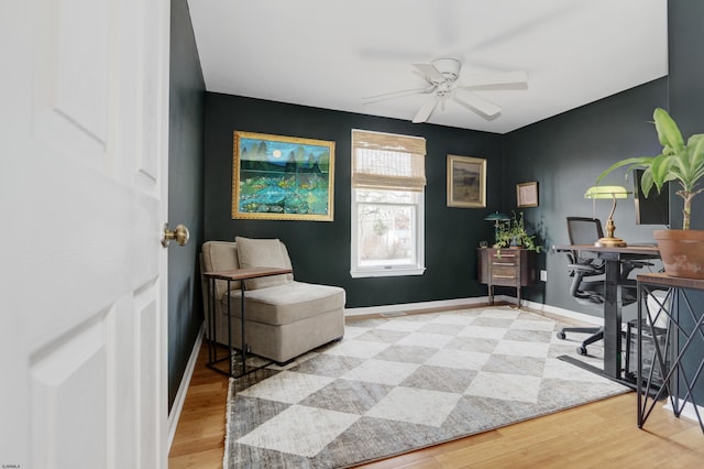 home office featuring wood finished floors, a ceiling fan, and baseboards