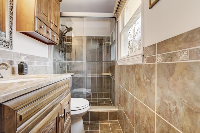 full bath featuring toilet, tile walls, a shower stall, and vanity