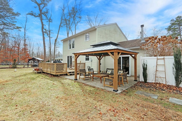 rear view of house featuring a wooden deck, a gazebo, fence, a yard, and a patio area