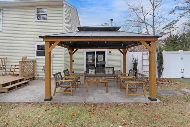 back of house featuring outdoor lounge area, a gazebo, a standing seam roof, fence, and metal roof