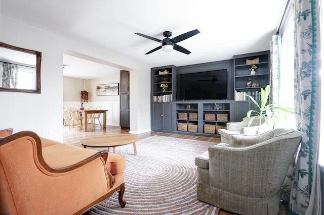 living room featuring light wood-type flooring and ceiling fan