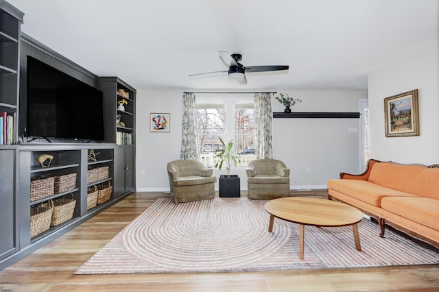 living room with ceiling fan, wood finished floors, and baseboards