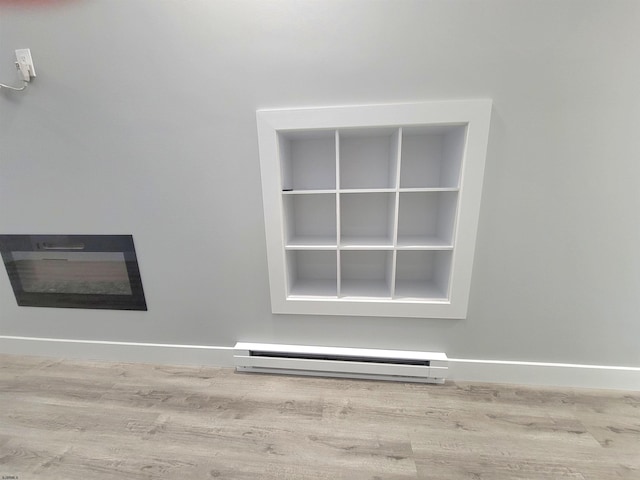 room details with baseboards, baseboard heating, and wood finished floors