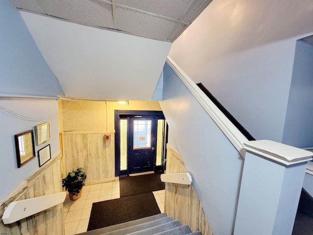 stairs with lofted ceiling and tile patterned flooring