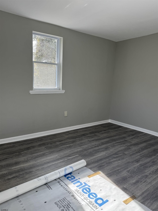 empty room with dark wood finished floors and baseboards