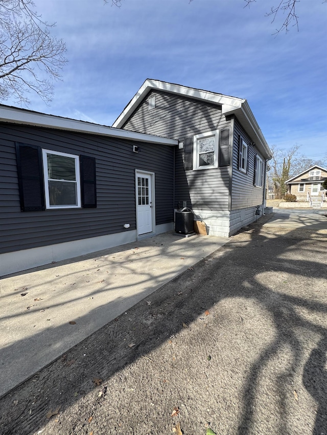 view of front of home with cooling unit and a patio