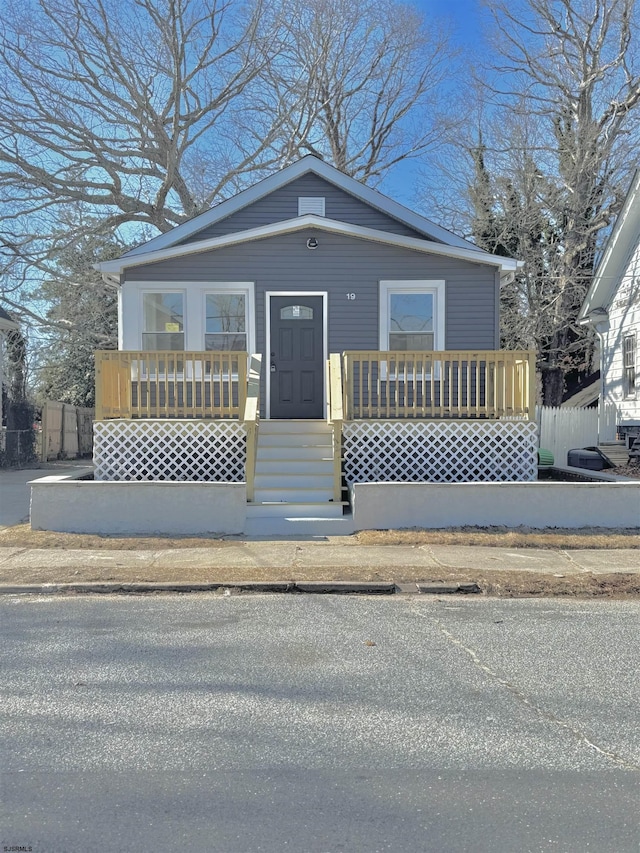 bungalow-style house featuring covered porch and fence