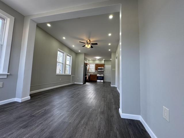 unfurnished living room with a ceiling fan, baseboards, dark wood-type flooring, and recessed lighting