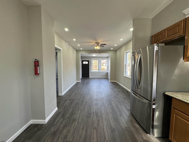 kitchen featuring baseboards, brown cabinetry, dark wood finished floors, freestanding refrigerator, and light countertops