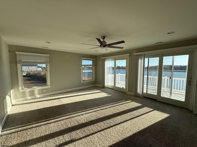 unfurnished sunroom with a water view, visible vents, and a ceiling fan