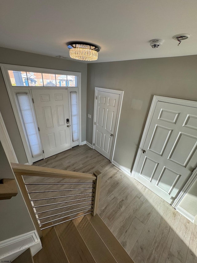 entrance foyer featuring stairway, wood finished floors, and baseboards