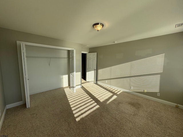 unfurnished bedroom featuring multiple windows, carpet floors, a closet, and baseboards