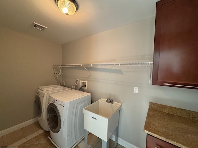 laundry room with laundry area, separate washer and dryer, a sink, visible vents, and baseboards