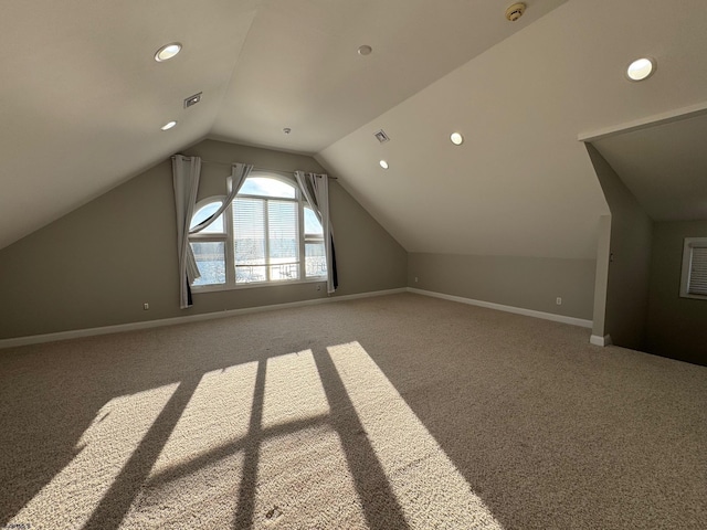 additional living space featuring lofted ceiling, carpet, visible vents, and baseboards