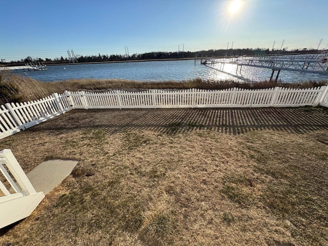 exterior space featuring a water view and fence