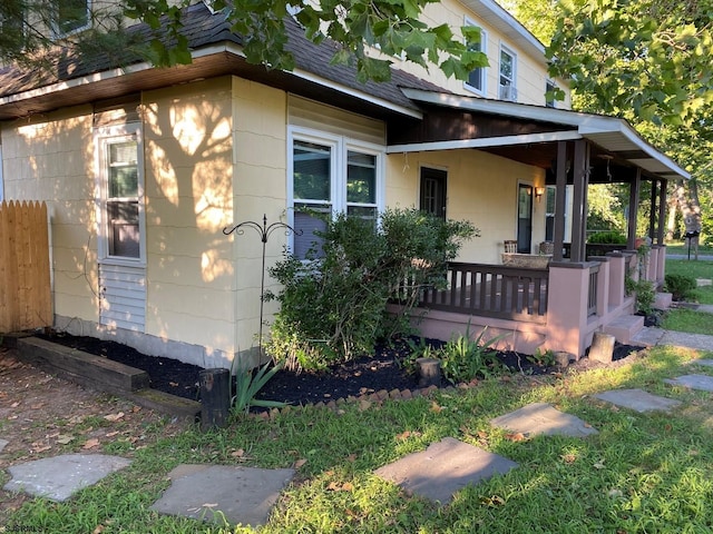 view of home's exterior with a shingled roof and covered porch