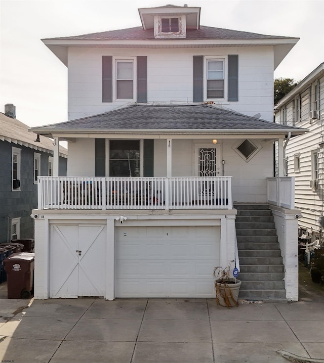 traditional style home featuring a shingled roof, concrete driveway, a balcony, and an attached garage