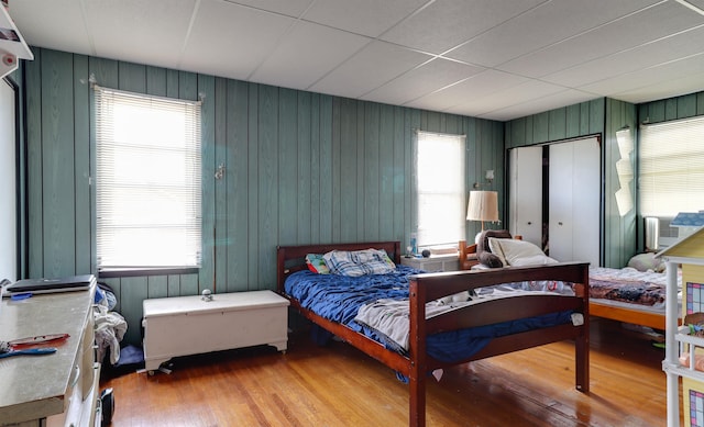 bedroom with multiple windows and wood finished floors