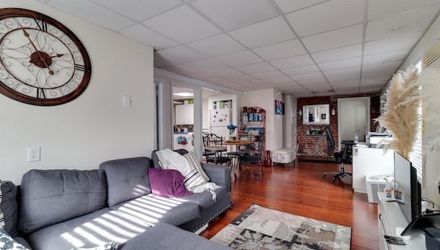 living area featuring dark wood-type flooring and a drop ceiling