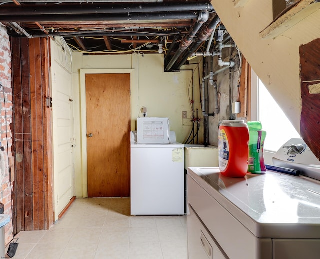 laundry area featuring laundry area, light tile patterned floors, and separate washer and dryer