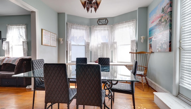 dining space featuring light wood-style floors and baseboards