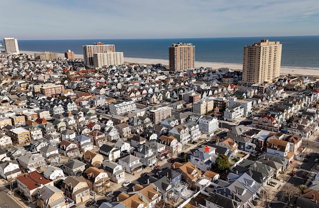 bird's eye view featuring a view of city, a water view, and a beach view