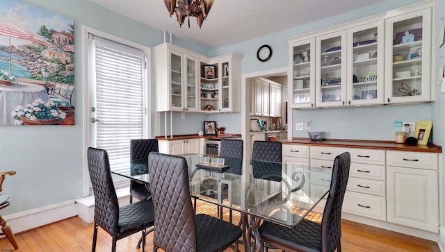 dining area featuring light wood-style flooring and baseboards