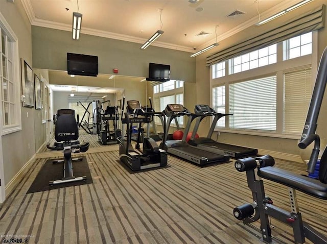 exercise room with ornamental molding, carpet, visible vents, and baseboards