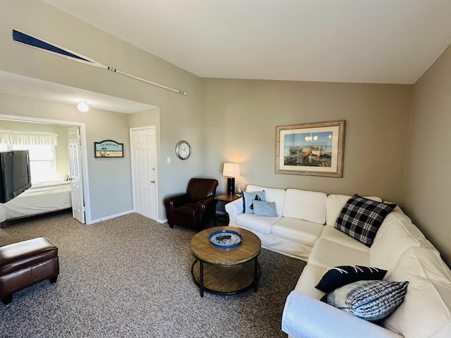 carpeted living area with lofted ceiling and baseboards